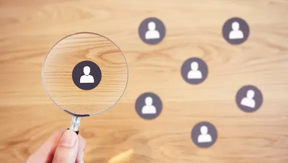 A magnifying glass over an icon of a person