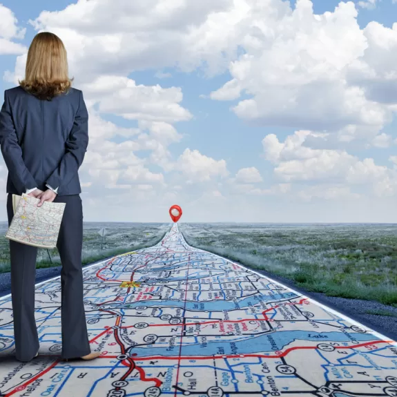 Woman looking down a long road that appears to be a map
