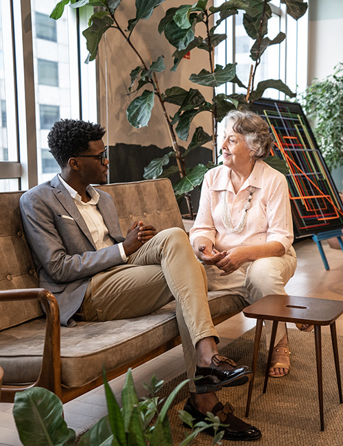 Two people sitting on a couch conversing