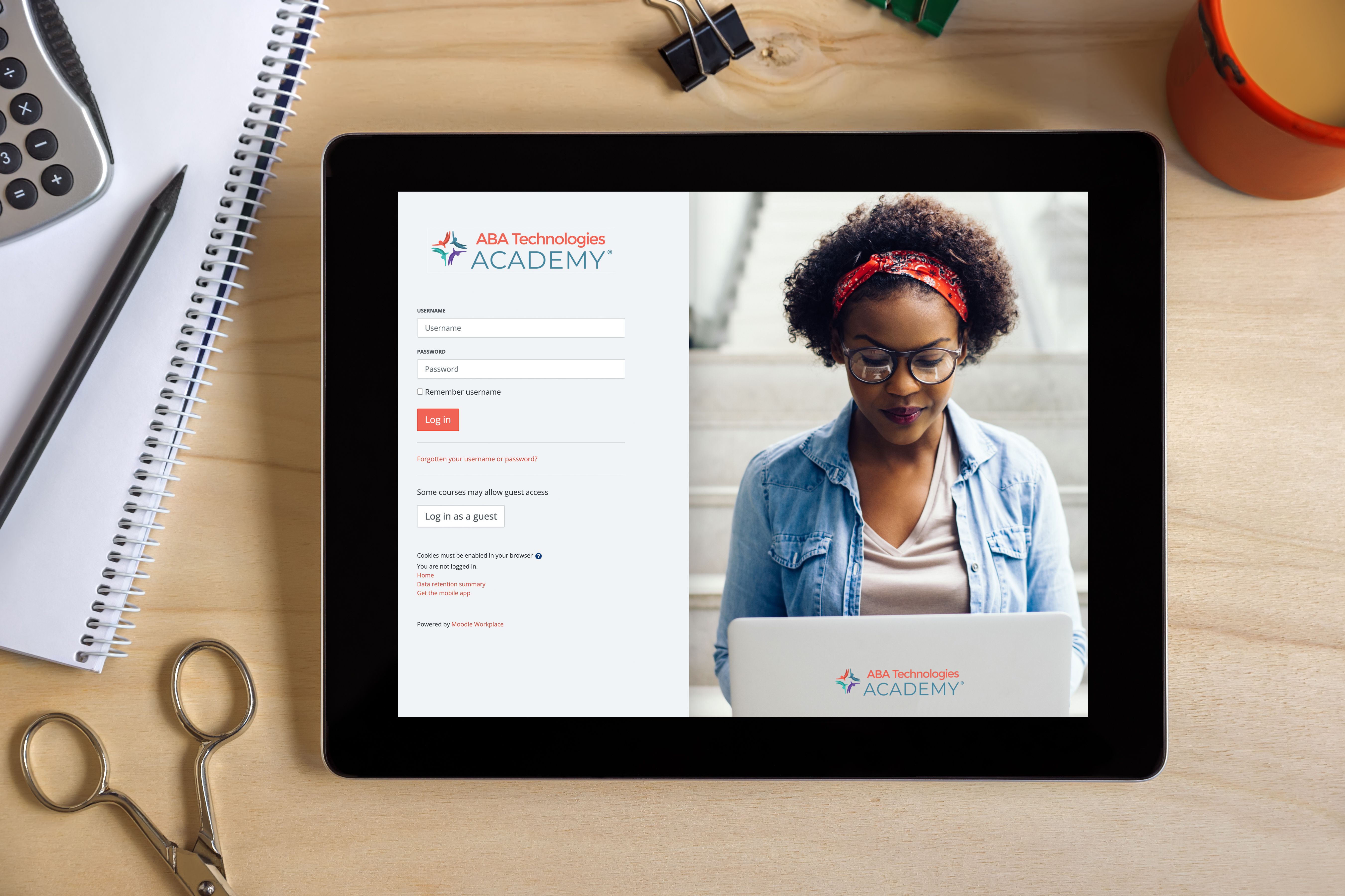 ABA tech academy login page on a tablet on a cluttered desk