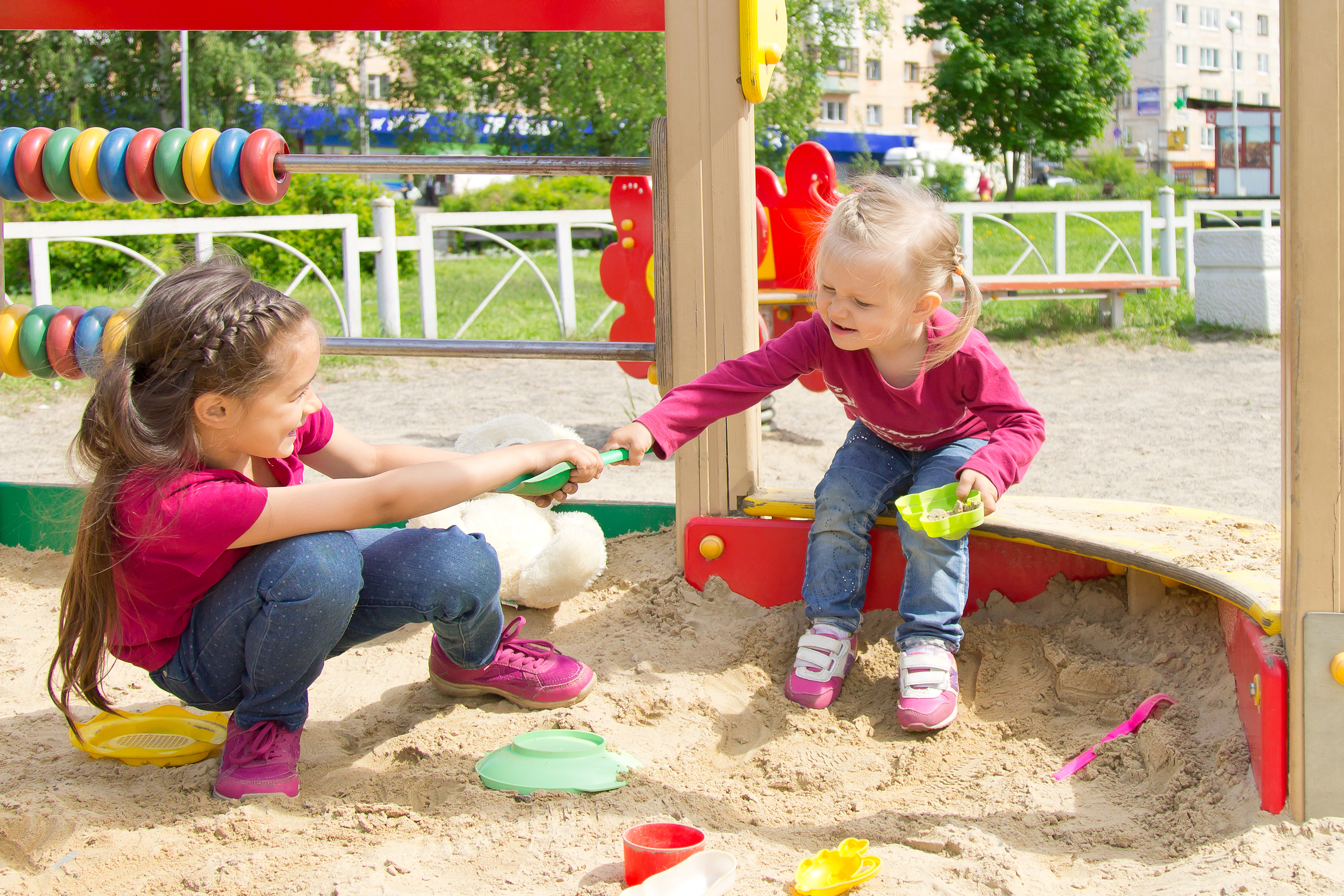 Two girls fighting in a sandbox