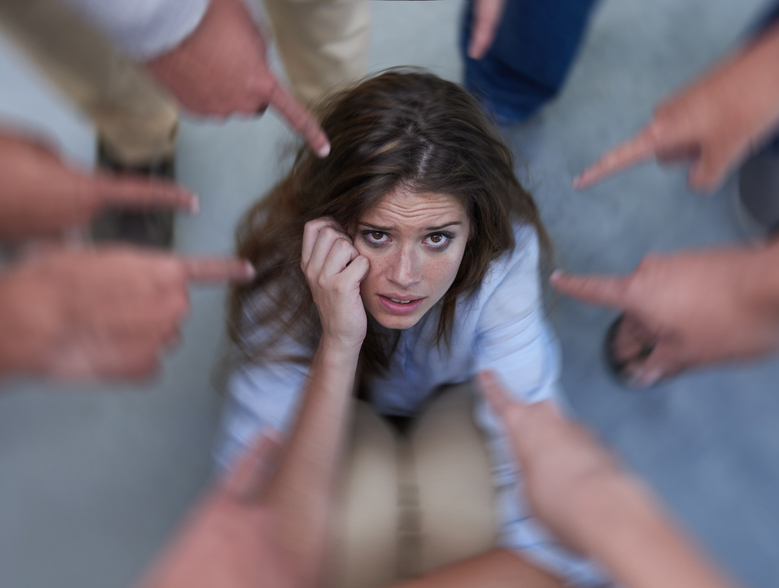 A women on the ground looking upset while multiple hands point at her