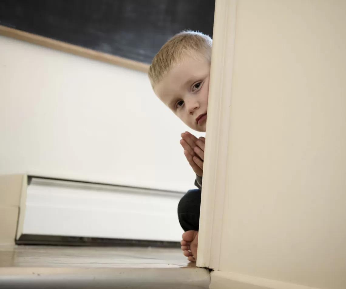 a child peaking around a doorframe