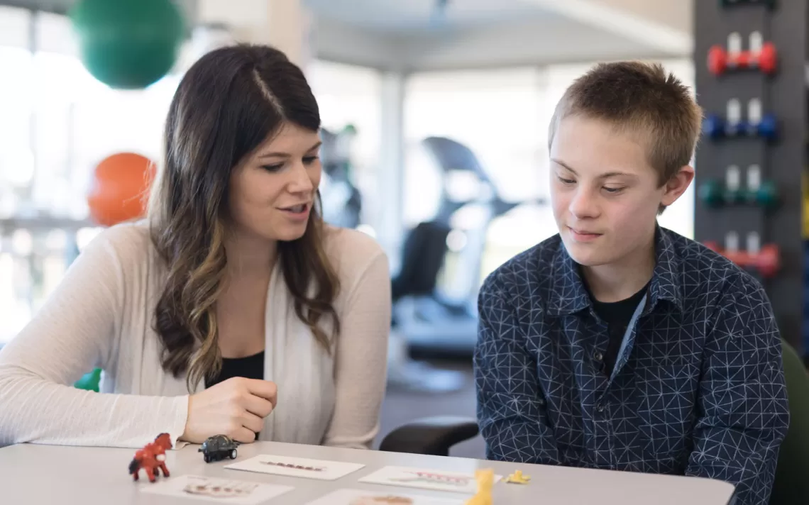 a teacher and a student going over work at a desk