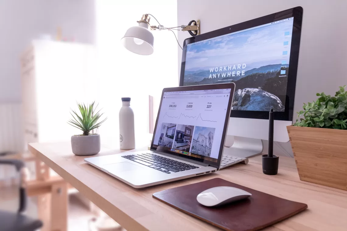 Laptop on a desk with a large screen