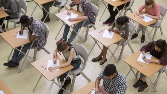 Students sitting at individual desks taking an exam