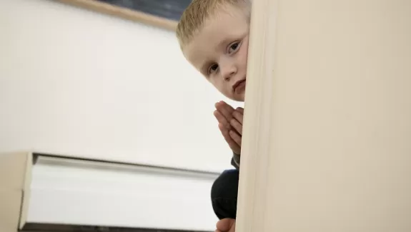 a child peaking around a doorframe