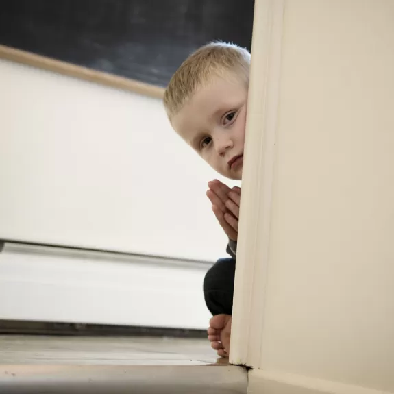 a child peaking around a doorframe